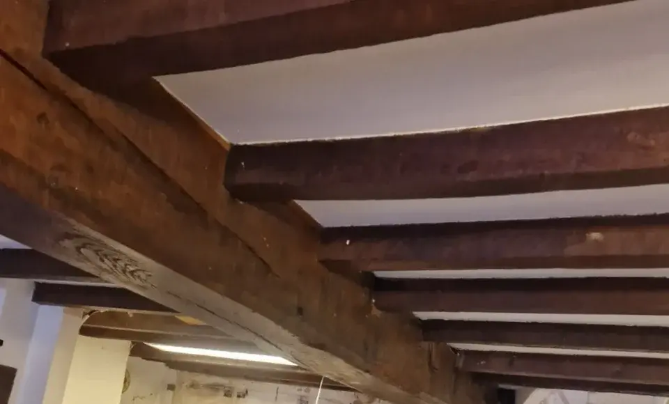 Dark stained oak beams — before
